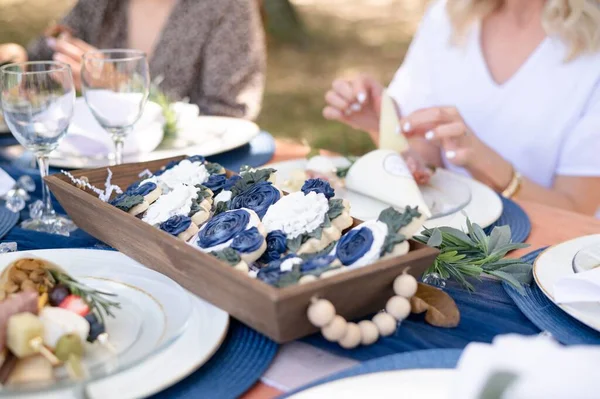 木製のトレイに白と青の花のクッキーのクローズアップショット — ストック写真