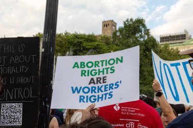 Protestocular, Anayasa Mahkemesi 'nin ABD' nin NYC eyaletindeki Washington Square Park 'ta Roe V. Wade' i devirmesinin ardından vücut özgürlüğüyle ilgili mukavva tabelalar tutuyorlar.