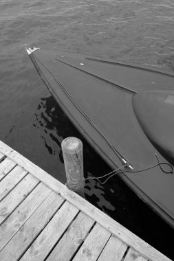 İskelede tahta bir direğe bağlanmış bir tekne.