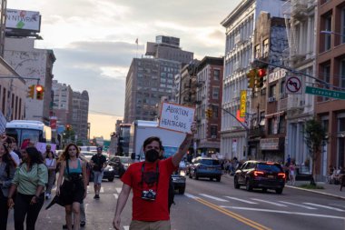 Protestocular, Anayasa Mahkemesi 'nin ABD' nin NYC eyaletindeki Washington Square Park 'ta Roe V. Wade' i devirmesinin ardından vücut özgürlüğüyle ilgili mukavva tabelalar tutuyorlar.