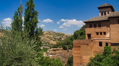 Ağaçlarla çevrili antik duvarları ve temelleri ile Alhambra kompleksi, Granada, İspanya