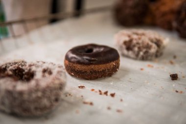 Seçici odak noktasında çikolatalı donut ve arka planda diğer donutlar bulanık.