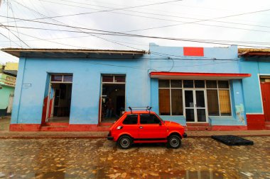 Güneşli bir günde Trinidad 'da renkli binalar ve park edilmiş bir araba manzarası.