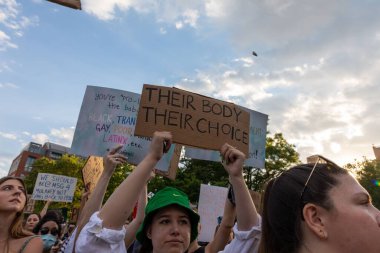 Protestocular, Anayasa Mahkemesi 'nin ABD' nin NYC eyaletindeki Washington Square Park 'ta Roe V. Wade' i devirmesinin ardından vücut özgürlüğüyle ilgili mukavva tabelalar tutuyorlar.