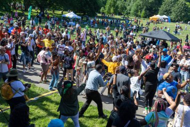 Güneşli bir günde Prospect Park Brooklyn 'de düzenlenen 13. Haziran kutlamasında bir kalabalık.