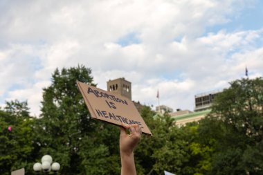 Protestocular, Anayasa Mahkemesi 'nin ABD' nin NYC eyaletindeki Washington Square Park 'ta Roe V. Wade' i devirmesinin ardından vücut özgürlüğüyle ilgili mukavva tabelalar tutuyorlar.