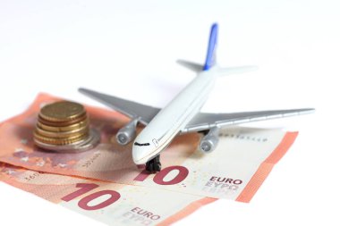 Avro banknotlarındaki bir uçak oyuncağı beyaz bir arkaplanda izole edilmiş - seyahat için tasarruf