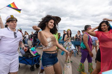 Coney Adası 'ndaki 40. Geleneksel Denizkızı Yürüyüşü' nde peruklu, parlak bluzlu ve şortlu bir çocuk.