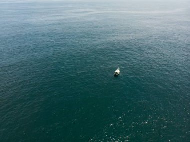 Açık denizde küçük bir geminin havadan görüntüsü.