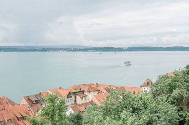 Constance Gölü 'nde beyaz bir yat Meersburg' daki evlerin ve yeşilliklerin arka planında