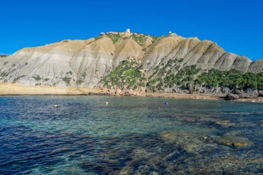 Dik mavi kil yamaçlar, kireç taşı üzerinde kayan döküntülerle birlikte Xatt l-Ahmar, Ghajnsielem, Gozo, Malta, güneşli bir günde.