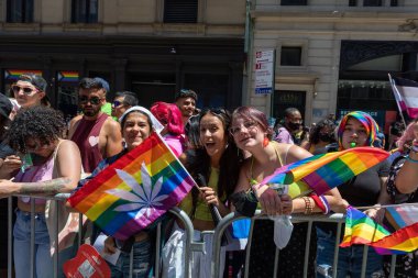 LGBT bayraklı bir kalabalık bir geçit töreninde fotoğraf çekmek için poz veriyor.