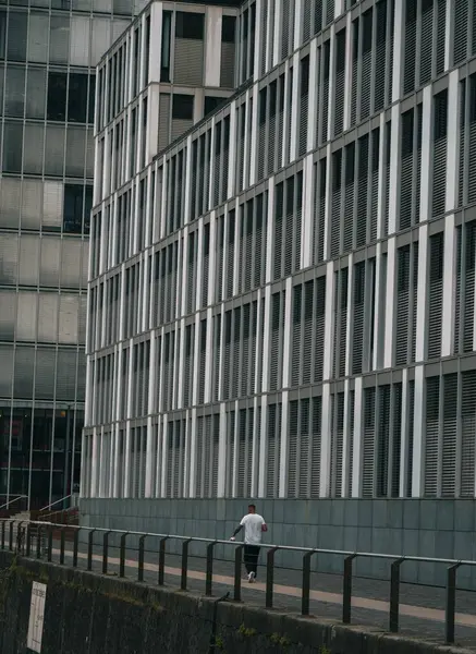 Osoba Przechodząca Obok Budynku Nowoczesną Fasadą — Zdjęcie stockowe