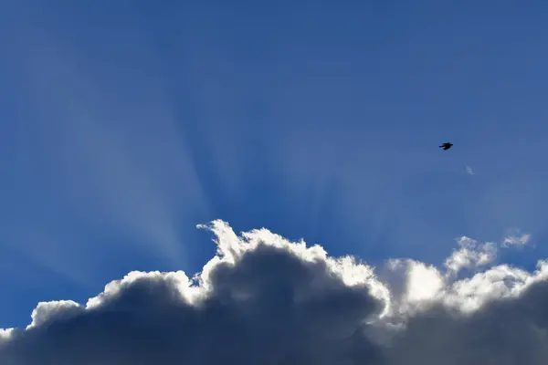 青い空に雲を通して輝く太陽の光の美しい景色 — ストック写真