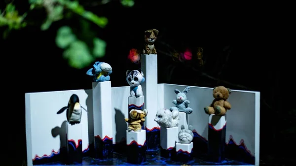 Cute Small Animal Figures Sitting Pillars Dark Background Close Shot — Stock Photo, Image