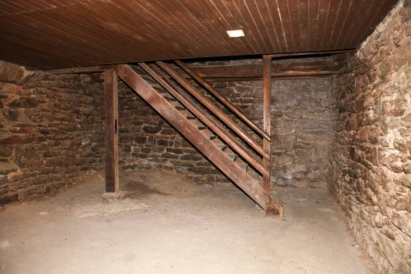 一间有石墙的空荡荡的房间内的木制台阶 — 图库照片