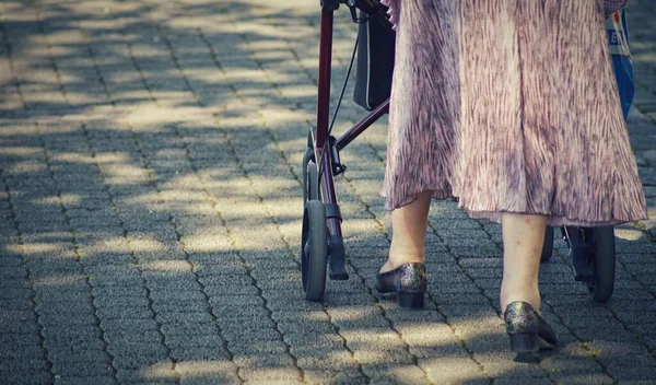 一张老年女子的特写照片 她在街上带着一个行走的滚筒 — 图库照片