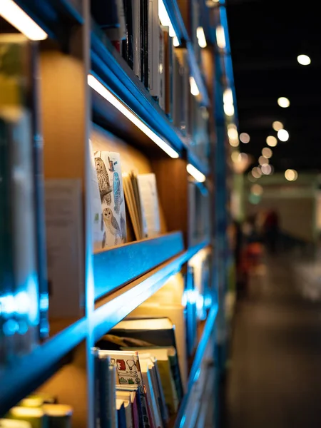 フクロウのカバー付きの本に焦点を当てた図書館や書店の棚の垂直ショット — ストック写真