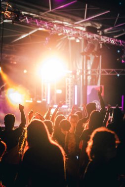 Dans eden kalabalık ve disko ışıklarının olduğu bir müzik etkinliği.