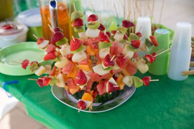 Şenlik masasında dilimlenmiş meyvenin seçici odak noktası.