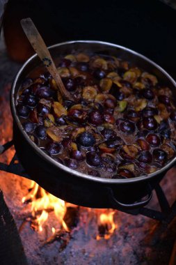 Kesilmiş eriklerin dikey yakın çekimi şöminenin üstünde pişiriliyor.