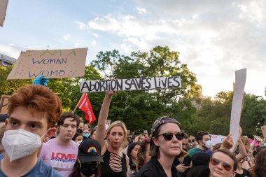 Protestocular, Anayasa Mahkemesi 'nin ABD' nin NYC eyaletindeki Washington Square Park 'ta Roe V. Wade' i devirmesinin ardından vücut özgürlüğüyle ilgili mukavva tabelalar tutuyorlar.
