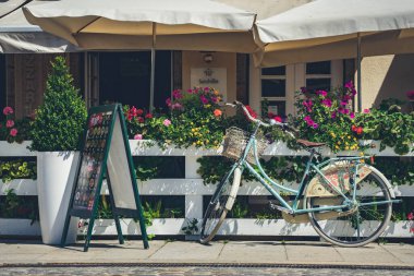 Renkli çiçeklerle dolu bir restoranın önünde bisiklet.