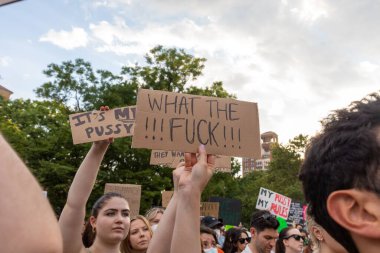 Protestocular, Anayasa Mahkemesi 'nin ABD' nin NYC eyaletindeki Washington Square Park 'ta Roe V. Wade' i devirmesinin ardından vücut özgürlüğüyle ilgili mukavva tabelalar tutuyorlar.