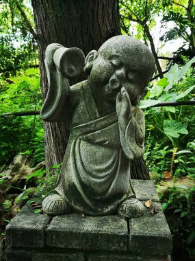 Miyajima 'nın Çok Şirin Jizo Heykeli' nin yakından çekilmiş bir fotoğrafı. Bir çan tutuyor ve ormanı çağırıyor.