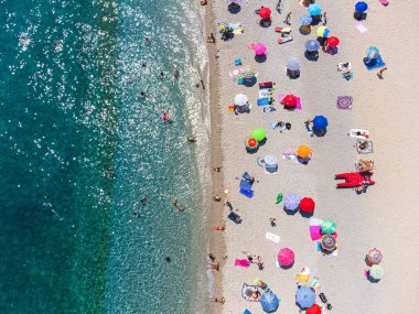 Hava manzaralı, turkuaz suyu olan bir halk plajı. Bergeggi, İtalya - Temmuz 2021