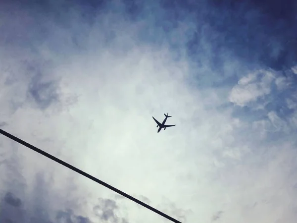 Parlak Mavi Gökyüzünde Uçan Bir Uçağın Alçak Açılı Görüntüsü — Stok fotoğraf