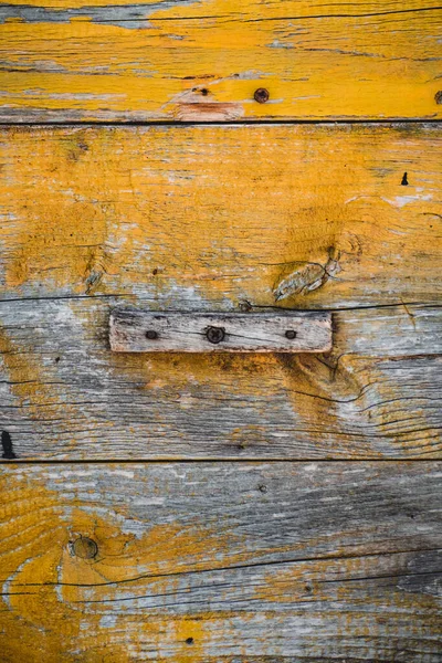 Vertikální Záběr Ošlehaného Dřevěného Povrchu Žlutou Barvou — Stock fotografie