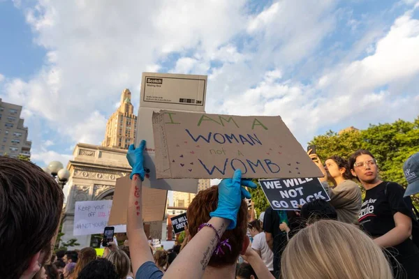 Protestocular, Anayasa Mahkemesi 'nin ABD' nin NYC eyaletindeki Washington Square Park 'ta Roe V. Wade' i devirmesinin ardından vücut özgürlüğüyle ilgili mukavva tabelalar tutuyorlar.