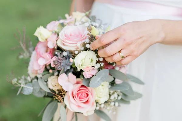 バラと結婚式の花束を保持白いドレスを持つ花嫁のクローズアップ — ストック写真