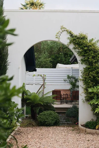 緑の植物と白いアーチを持つ美しい屋外シーティングエリアの垂直ショット — ストック写真