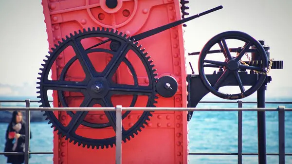 港口的黑色巨型齿轮与红色表面相映成趣 — 图库照片