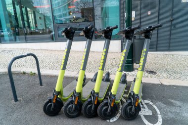 Lizbon, Portekiz 'de beş yeşil elektrikli scooter iyi park edilmiş.