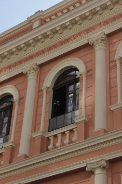 Dikey çekimde pembe bir binanın açık penceresinin yakın çekimi