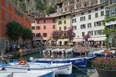 İtalya 'daki Garda Gölü kıyısında renkli binalarla çevrili küçük bir liman manzarası.