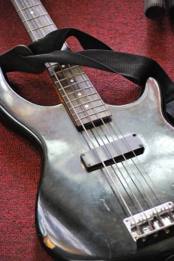 Kırmızı halıdaki gümüş elektro gitarın üst görüntüsü.