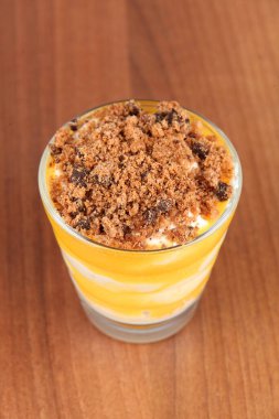 Küçük bir bardak limon ve ahşap bir masada mascarpone kreması.