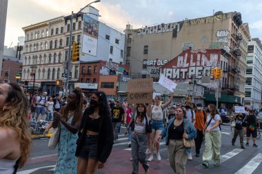 Protestocular, Anayasa Mahkemesi 'nin ABD' nin NYC eyaletindeki Washington Square Park 'ta Roe V. Wade' i devirmesinin ardından vücut özgürlüğüyle ilgili mukavva tabelalar tutuyorlar.