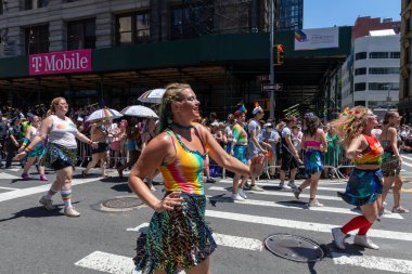 LGBT renkleri olan bir kalabalık bir geçit töreninde yürüyor.