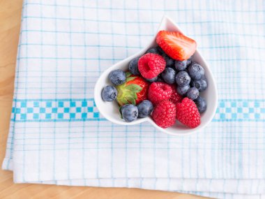 Böğürtlenlerin üst görüntüsü beyaz bir kase üzerine yerleştirilmiş.