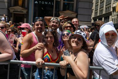 LGBT renginde bir kalabalık bir geçit töreninde fotoğraf için poz veriyor.