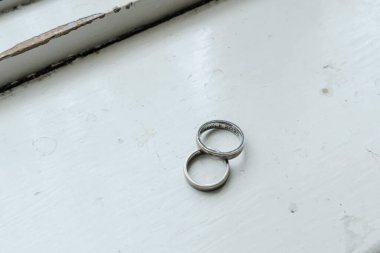 Pencere kenarındaki iki güzel alyansın yakın plan çekimi.