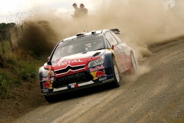 Toprak yolda yarışan bir ralli arabası..