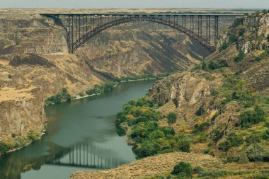 Idaho 'nun güzel doğasıyla çevrili yılan nehri üzerindeki bir köprünün manzarası.