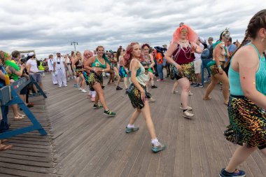 Coney Adası 'ndaki 40. Geleneksel Denizkızı Geçidi sırasında bir kalabalık dans ediyor.