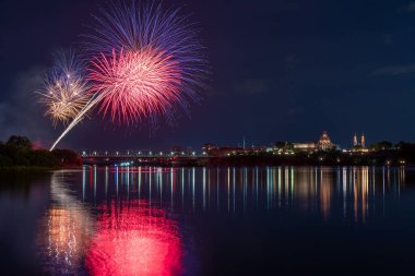 Göl kıyısında, gece gökyüzünde havai fişeklerin güzel manzarası.